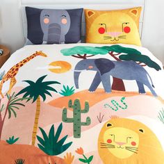 a bed with an animal themed comforter and two pillow cases on top of it