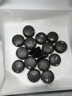 black and white candies in a box with snow flakes on them, ready to be eaten