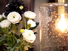 a close up of a vase with flowers and a light