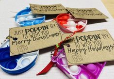 four different colored plastic bowls with tags on them sitting on a sheet of white paper