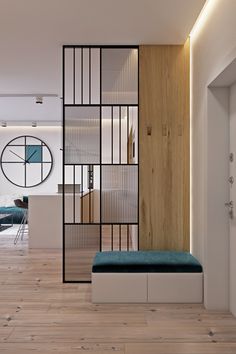 a room with wood flooring and white walls next to a blue bench in front of a window