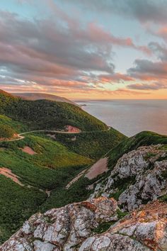 the view from top of a mountain looking down at an ocean and mountains in the distance