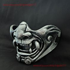 a metal mask that looks like a demon's head with teeth and fangs on it