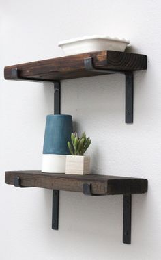 two wooden shelves with pots and plants on them, one shelf has a blue vase