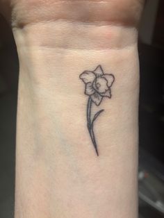 a small flower tattoo on the wrist