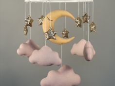 a mobile with stars, moon and clouds hanging from it