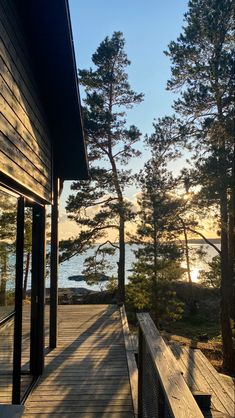 a wooden deck leading to the water and trees