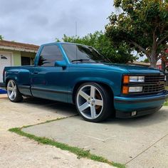 a blue pick up truck parked in front of a house