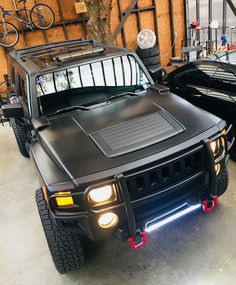 two black hummer trucks parked in a garage