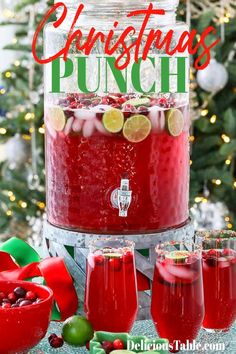 a christmas punch in a glass with limes and cranberries on the side