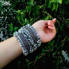 This beautiful bracelet features exquisite rava work and the perfect detailing to adorn your wrists. Moreover, this German silver Indian jewelry has an oxidized silver finish that makes it a truly wearable piece of Indian jewelry on a regular basis. This South Indian jewelry, handcrafted by renowned artisans, is interlinked with each element encircled by ghungroos that will instantly bring a touch of bohemian to your look. Don't wait to buy this stunning bangle from Vastrabhushan and get an assu Adjustable Heavy Bracelets, Adjustable Bangle With Latkans, Metal Bracelets With Latkans For Festival, Silver Bangles For Women, Indian Jewelry Silver, Boho Bangles, Belly Dance Dress, Boho Bangle, Bangles For Women