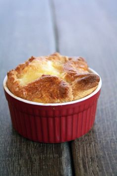 a red dish filled with food sitting on top of a wooden table