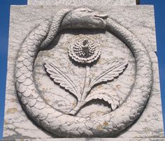 a close up of a stone sculpture with a bird on it's back end