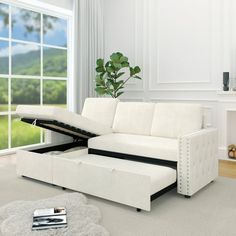 a living room with a white couch and ottoman in front of a large open window