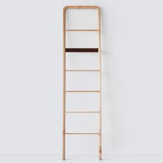 a wooden ladder leaning against a white wall