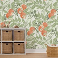 an orange and green floral wallpaper in a living room with baskets on the floor