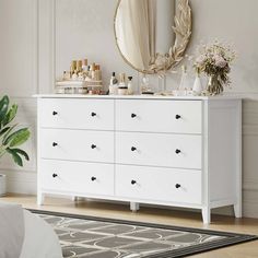 a white dresser and mirror in a room