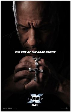 a man holding a cross in his hands with the words x - men on it