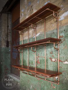 an old wall with some metal pipes on it and shelves in front of the wall