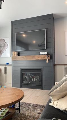 a living room with a fireplace and television on the wall