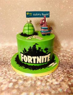 a green cake with the name fortnite on it and an animal figurine