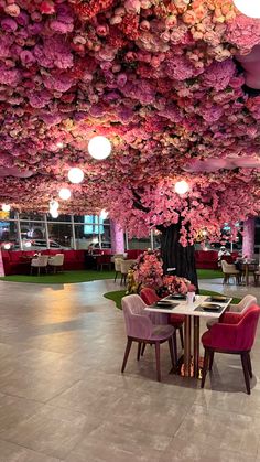 an indoor dining area with pink flowers on the ceiling