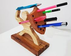 a wooden holder with pens and pencils in it