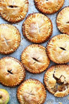 apple pies on a baking sheet with an apple in the background