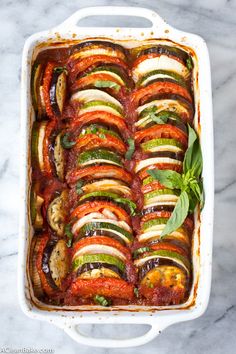 a casserole dish filled with vegetables and sauce