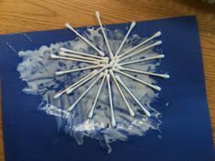 a bunch of white sticks sitting on top of a blue piece of paper