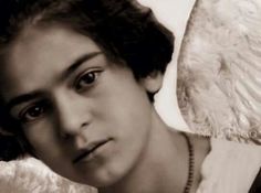 black and white photograph of a woman with an angel wings on her shoulder, looking at the camera