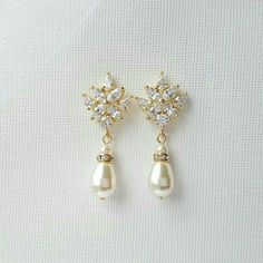 a pair of earrings with pearls and diamonds on them, sitting on a white surface