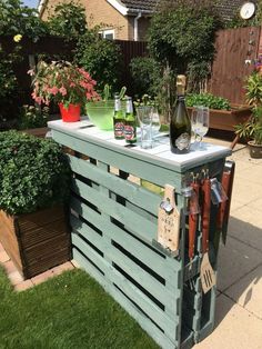 an outdoor bar made out of pallet wood with bottles and glasses on the top