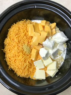 cheese and other ingredients in a crock pot ready to be put into the slow cooker