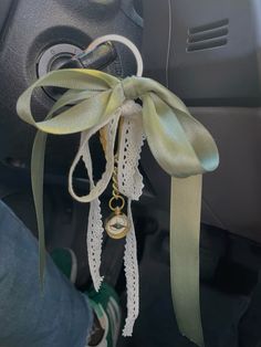 a car door handle with a ribbon tied around it and a key hanging from the front