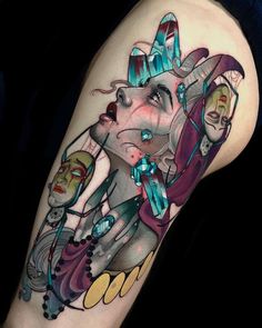 a woman's leg with an artistic tattoo design on her thigh and the image of two clowns