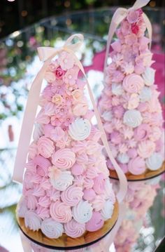 two cupcakes decorated with pink and white frosting are sitting on a table