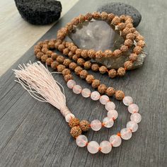 A most have addition to your Mala Necklace collection. A knotted mala with a mix of rose quartz beads and Rudraksha beads with a light pink tassel at the bottom. A stylish necklace that will also keep you grounded. Use it as a necklace, as a bracelet, even as a decor item in your room, or praying/ meditating area. The mala is 47cm- 18.5 inch drop length (without the tassel) The bottom tassel is 7.5cm- 3 inch long. The perfect gift for your loved ones. ⚡️Join Akashi's VIP list for early bird disc Pink Spiritual Crystal Necklace For Meditation, Rose Quartz Necklace With Gemstone Beads For Meditation, Rose Quartz 108 Beads Jewelry For Meditation, Spiritual Rose Quartz Crystal Necklace For Meditation, Pink Meditation Necklaces With Round Beads, Adjustable Spiritual Rose Quartz Beaded Necklaces, Pink Round Beads Necklace For Meditation, Spiritual Rose Quartz Beaded Necklaces For Healing, Spiritual Healing Rose Quartz Beaded Necklaces