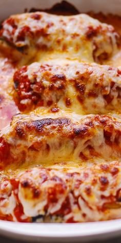 two slices of pizza sitting in a white casserole dish with sauce and cheese