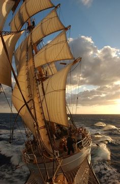 an image of a sailboat in the ocean with people on it's side