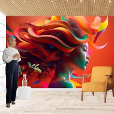 a woman standing in front of a colorful wall mural