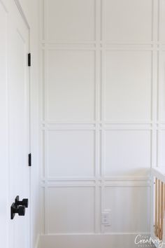 an empty room with white walls and black handles