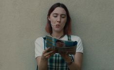 a woman with red hair is reading a book