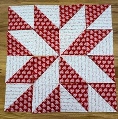 a red and white quilted block on top of a wooden table