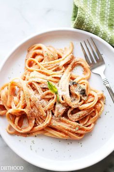 a white plate topped with pasta covered in sauce