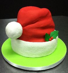 a red and white santa hat on top of a green plate