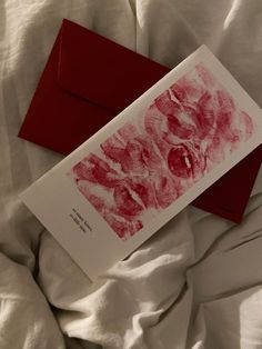 a red envelope sitting on top of a white bed