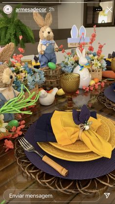 an easter table setting with bunny figurines on the plates and napkins in front of them