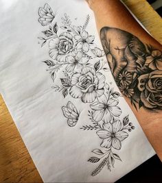 a woman's arm with flowers and an elephant tattoo on it