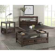 a coffee table with two end tables on top of it and a book shelf in the middle